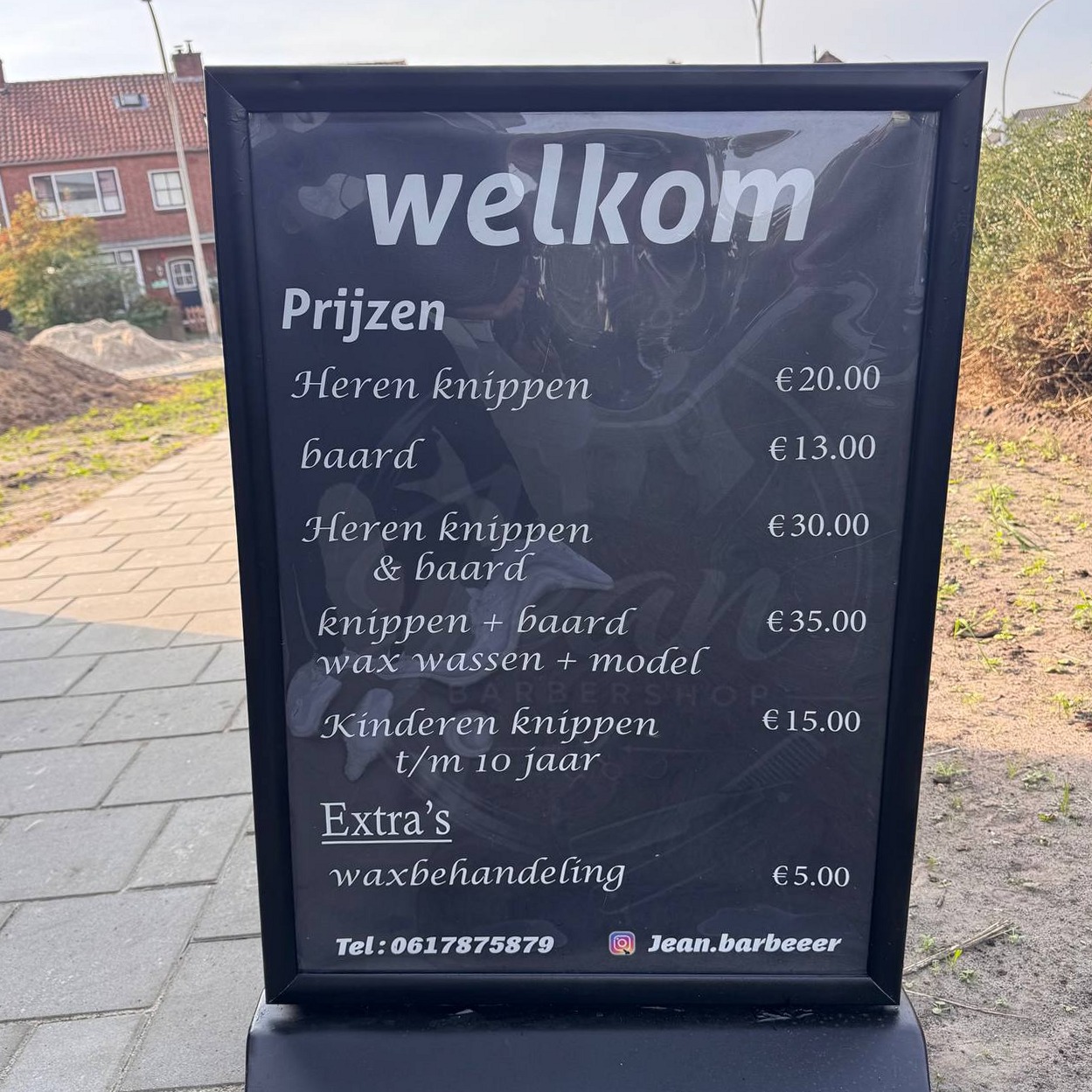 Het stoepbord van Barbershop Jean met welkom en de prijzen